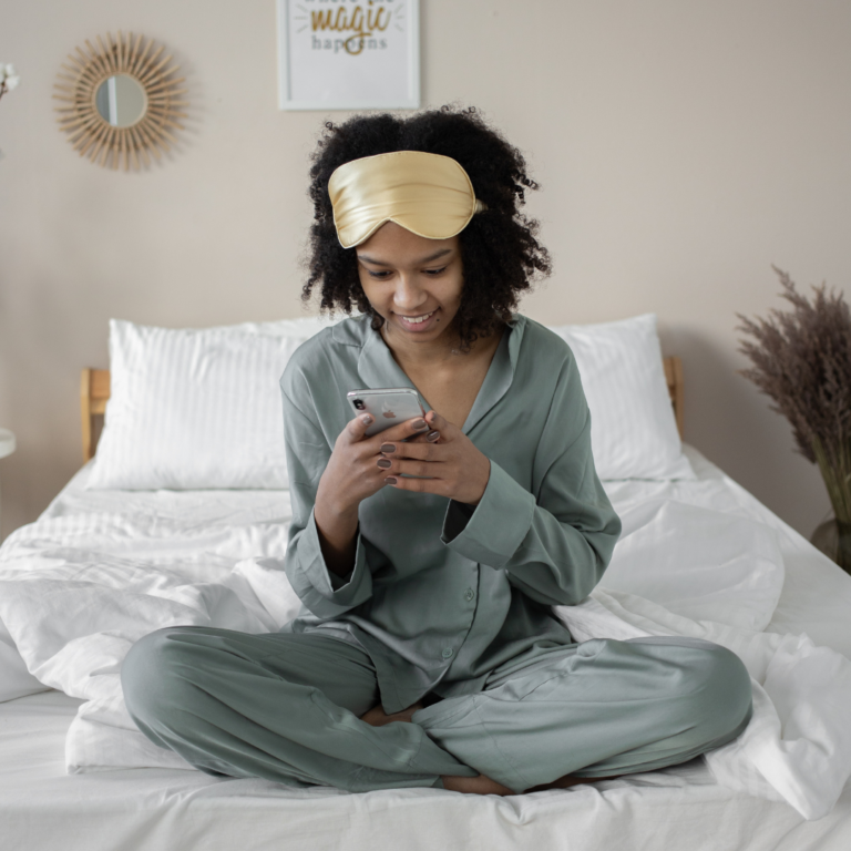 Woman looking at her phone in bed.